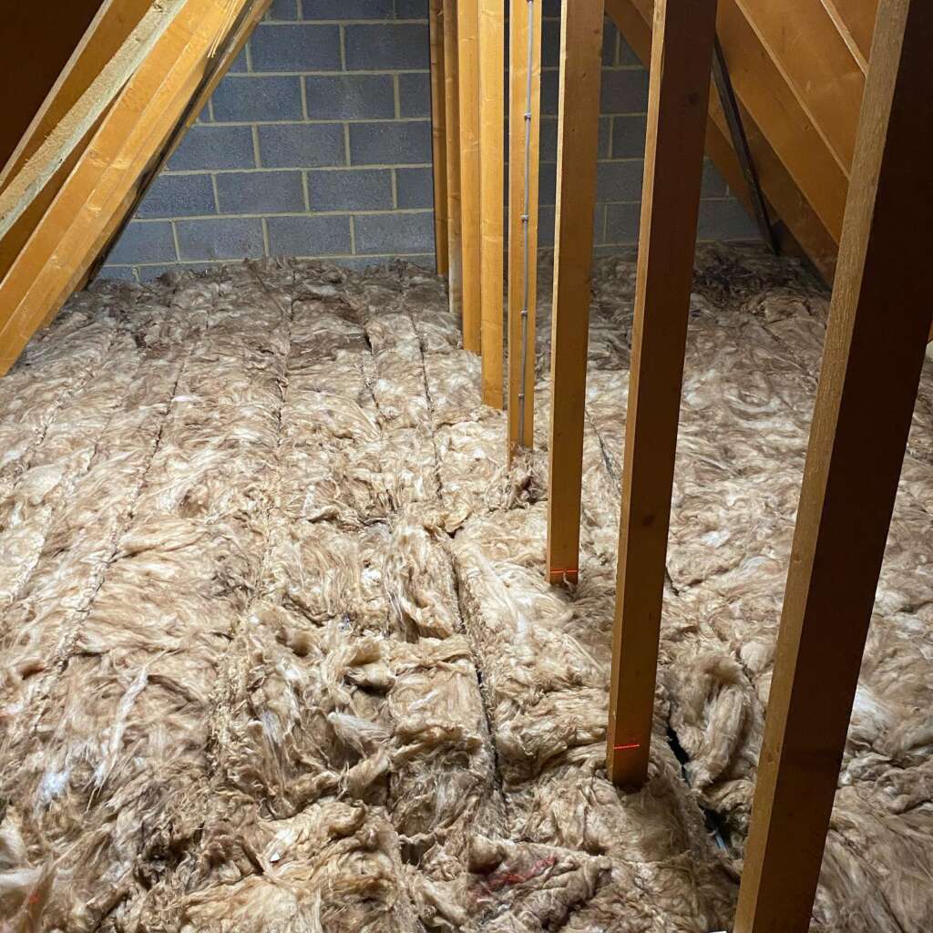 Before photo of loft insulation and exposed joists in Sussex home