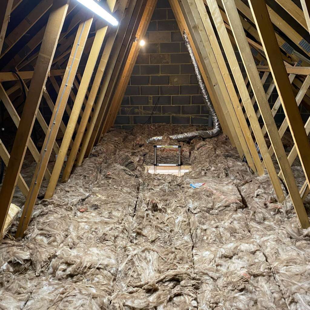 Before photo of cluttered loft area without boarding in Sussex